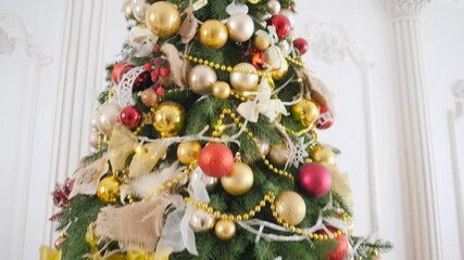 Wall Mural - Closeup panning shot of beautiful decorations and garlands on Christmas tree in living room at house. Winter holidays background or backdrop.