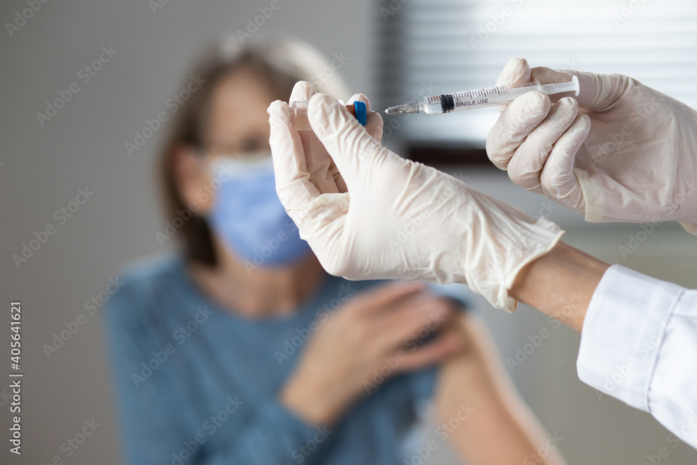 elderly woman getting coronavirus vaccine - obrazy, fototapety, plakaty 