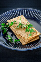 Wall Mural - Crispy bread on a blue plate with a diet vegetable