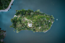 Top Down Aerial View Of Small Green Island In A Blue Lake