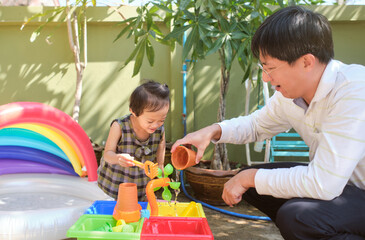 Happy Asian father and daughter having fun playing with water table at home, Wet Pouring Montessori Preschool Practical Life Activities, Fine Motor Skills development, Stay home Stay safe Have fun