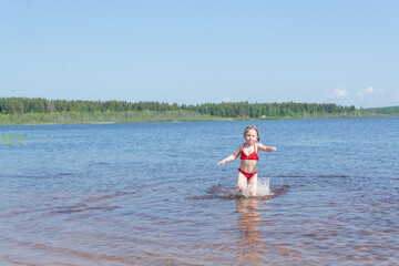 Wall Mural - A girl plays in the water on a hot sunny day.