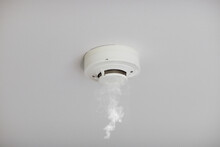 Smoke Detector On White Ceiling. Close Up Of Smoke Detector For Fire Protection Systems. Selective Focus.