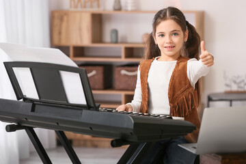 Wall Mural - Little girl taking music lessons online at home