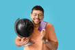 © Pixel-Shot - Male tourist with globe and passport on color background