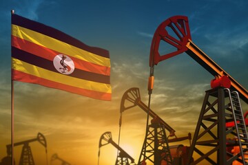 Wall Mural - Uganda oil industry concept. Industrial illustration - Uganda flag and oil wells against the blue and yellow sunset sky background - 3D illustration