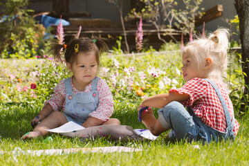 Wall Mural - Two little girls sisters paint with finger paints