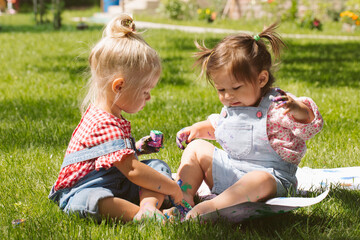 Wall Mural - Two little girls sisters paint with finger paints