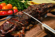 Grilled lamb breast and flap on wooden cutting board