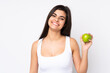 © luismolinero - Young woman over isolated white background with an apple and happy