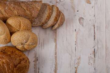 Sliced bread and other types of bread on a wooden table