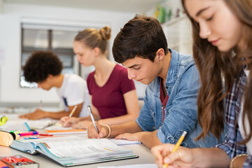 high school students doing exam in classroom