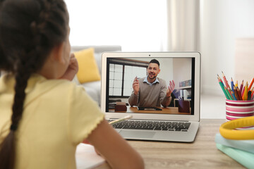 Distance learning, studying at home. Girl having online school lesson with teacher during quarantine and lockdown due to Covid-19 pandemic