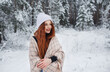 © Tatsiana - A young girl with long bright red hair on a winter background.A red-haired woman in a white cap.