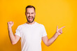 © deagreez - Portrait of attractive cheerful guy showing copy space ad celebrating luck isolated over bright yellow color background
