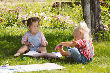 Wall Mural - Two little girls sisters paint with finger paints