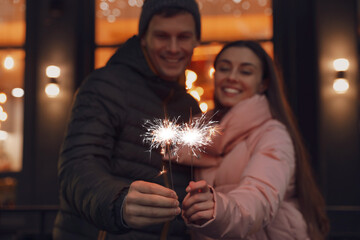 Wall Mural - Happy couple with sparklers at winter fair