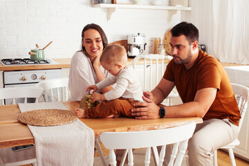 young family with little cute son on kitchen in morning happy smiling, lifestyle people concept