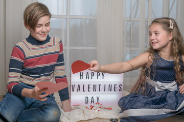 beautiful young couple boy and girl with paper hearts gift