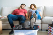 © PhotoAlto - Young couple relaxing on sofa in their new house