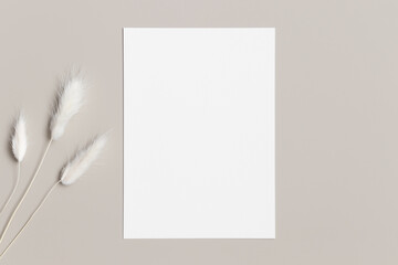 Wall Mural - White invitation card mockup with a lagurus on a beige table. 5x7 ratio, similar to A6, A5.