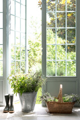 Wall Mural - vertical shot of freshly picked flowers and plants in a basket and a bucket and rubber boots