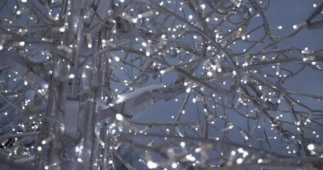 Wall Mural - A beautiful shot of Christmas led lights outdoors on the metallic tree covered in snow in 4K