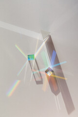 Glass geometric figures prisms with light diffraction of spectrum colors and complex reflection with trendy light and hard shadows on a white background