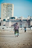 Fototapeta  - gypsy woman walking on the beach, Mar del Plata, Buenos Aires, Argentina