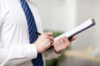 © eastfenceimage - Portrait of young businessman writing in office,close-up
