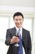 © eastfenceimage - Portrait of businessman holding a glass of wine