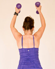 Pilates Woman Exercising Arms With Dumbbells Purple Weights Plain Background
