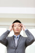 © eastfenceimage - Portrait of young businessman doing eye exercises