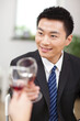 © eastfenceimage - Portrait of businessman holding a glass of wine and toasting