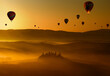 group of hot air balloons flying at dawn above the misty hills in Tuscany
