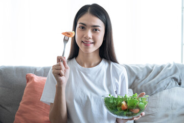 Wall Mural - Healthy eating ideas, Young Asian woman eating healthy food.