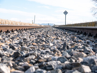 Poster - Beautiful selective shot of a railroad with small stones in a daytime under the blue sky