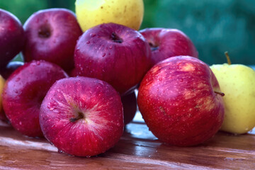 Sticker - Closeup shot of red and yellow apples with water drops on a wooden table