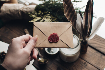 Letter seal with wax seal stamp on the wood table. Vintage notary stamp and sealed envelope. Post concept. Sealing wax. Wax seal. Dark academia style. Scandinavian hygge styled composition.