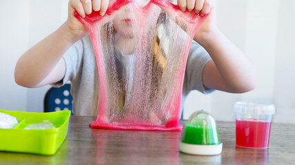 girl playing with slime toy at home  stretching it in hands, selecting focus