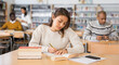 © JackF - Portrait of young adult woman studying in at public library