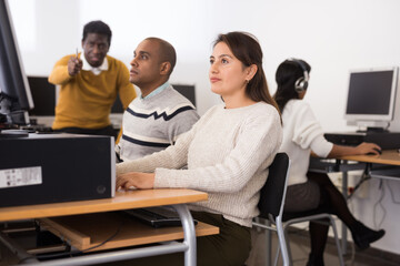 Portrait of focused young female student studying in university computer class