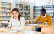 © JackF - Portrait of young adult woman studying in at public library