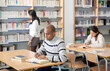 © JackF - Young adult man working with books, finding information at library