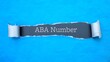 ABA Number. Blue torn paper banner with text label. Word in gray hole.