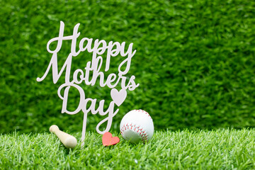 Baseball for mom on mother's day on green grass background