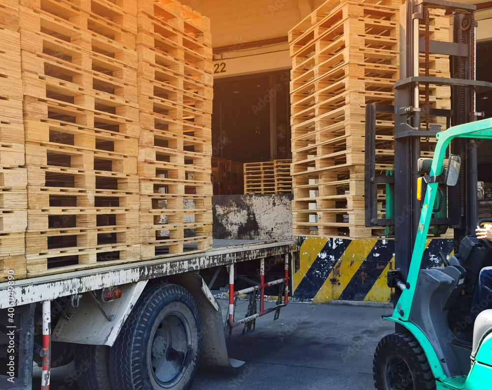 Worker driving forklift to loading and unloading wooden pallets from ...