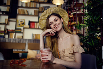 Beautiful woman sits at a table in a cafe glass of juice relaxation more fun