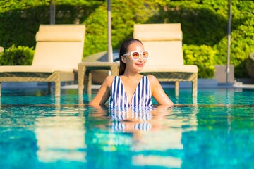 Portrait beautiful young asian woman relax smile leisure on vacation around swimming pool