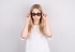 © Studio Nova - Young woman with glasses is very surprised looking and lowering her glasses. Surprise and shopping concept on white background.